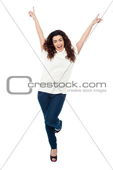 Joyous woman dancing with arms raised
