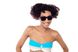 Smiling curly haired bikini model in dark shades