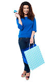 Shopaholic woman holding shopping bags and credit card