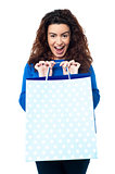 Excited woman holding shopping bags gently
