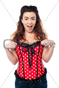 Excited woman adjusting her polka dotted corset top