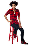 Casual young woman sitting on stool