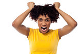 Angry young woman pulling her hair out