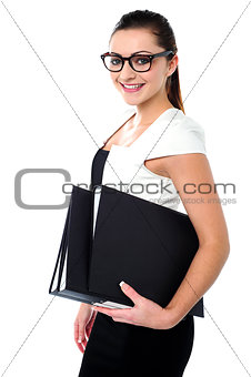 Young business professional posing with folders