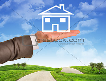 Businessmans hand holding wire-frame house 
