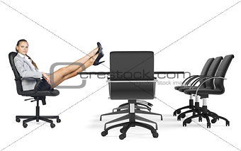Businesslady sitting in chair with her crossed legs on table