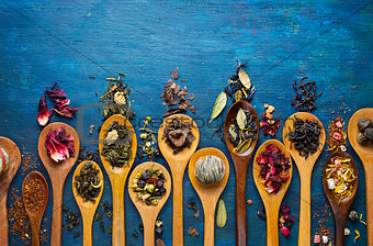 Dry tea with in wooden spoons.