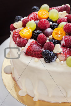 White chocolate cake decorated with fresh berries and fruits