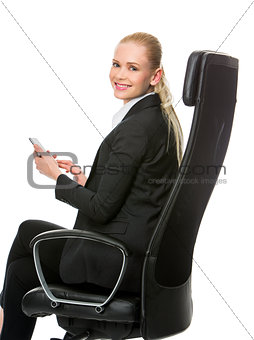 businesswoman seated on a chair working with tablet