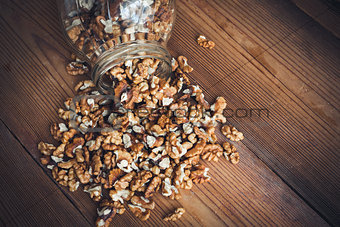 Walnut kernels and whole walnuts wood background