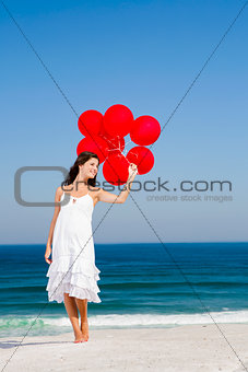 Beautiful girl holding red ballons