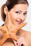 Beautiful woman holding a starfish