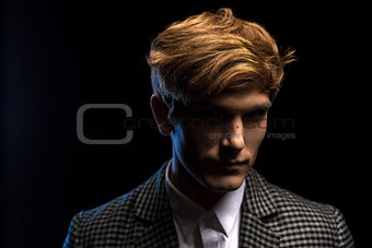 Portrait of red-haired handsome guy on a black background