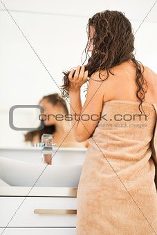 Young woman with wet hair in bathroom. rear view