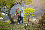 Young couple with toddler boy standing on cliff and enjoying valley view