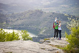 Young couple with toddler boy standing on cliff and smiling