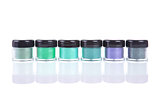 Row of green mineral eye shadows in clear plastic jars 