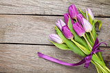 Purple tulips over wooden table