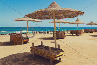 Deserted beach with wattled sun umbrellas