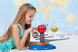 Little girl studies the solar system in geography class