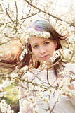 Portrait of cheerful fashionable woman in spring blooming tree