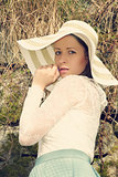Cheerful fashionable woman in stylish hat and frock posing