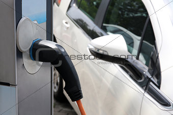 Electric car being charged at the station, close up of the power