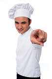 Smart young chef pointing at camera