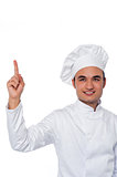 Male chef looking and pointing upwards