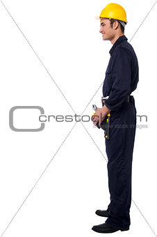 Side pose of smiling young construction worker