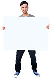 Handsome guy holding blank ad board