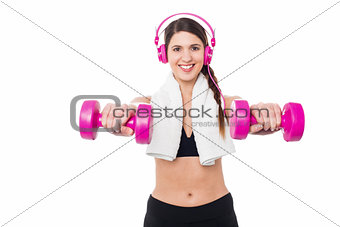 Woman enjoying music while doing dumbbells