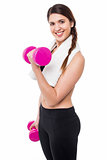 Young girl lifting dumbbells, biceps exercise