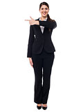 Attractive corporate woman pointing away
