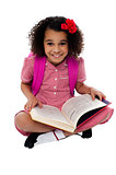 Smiling pretty school girl reading a book