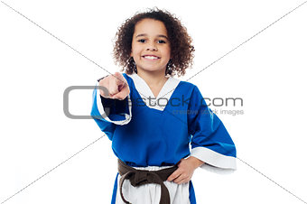 Smiling karate girl pointing towards you