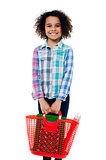 Happy school girl carrying stationery in basket