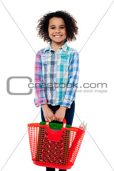 Happy school girl carrying stationery in basket