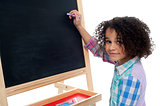 Beautiful little girl writing on classroom board