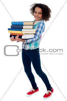 Active young school kid carrying books