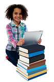 Smiling child busy with tablet pc and books