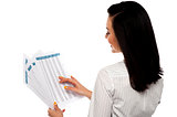 Back pose of businesswoman reading reports