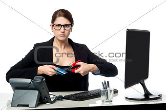 Serious faced woman cutting her credit card