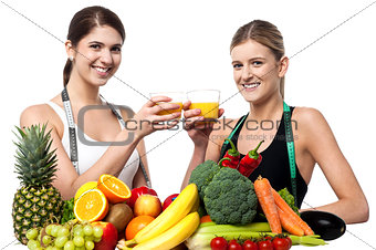 Young smiling girls each holding glass of juice