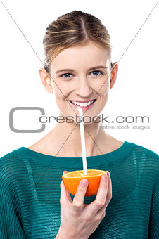 Girl sipping orange juice through straw