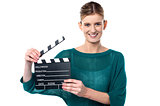 Young girl posing with clapperboard