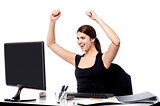 Excited business woman raising her hands.
