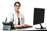 Smiling female doctor working on computer