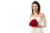 Pretty bride posing with love red roses bouquet