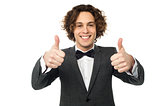 Joyous young guy gesturing double thumbs up